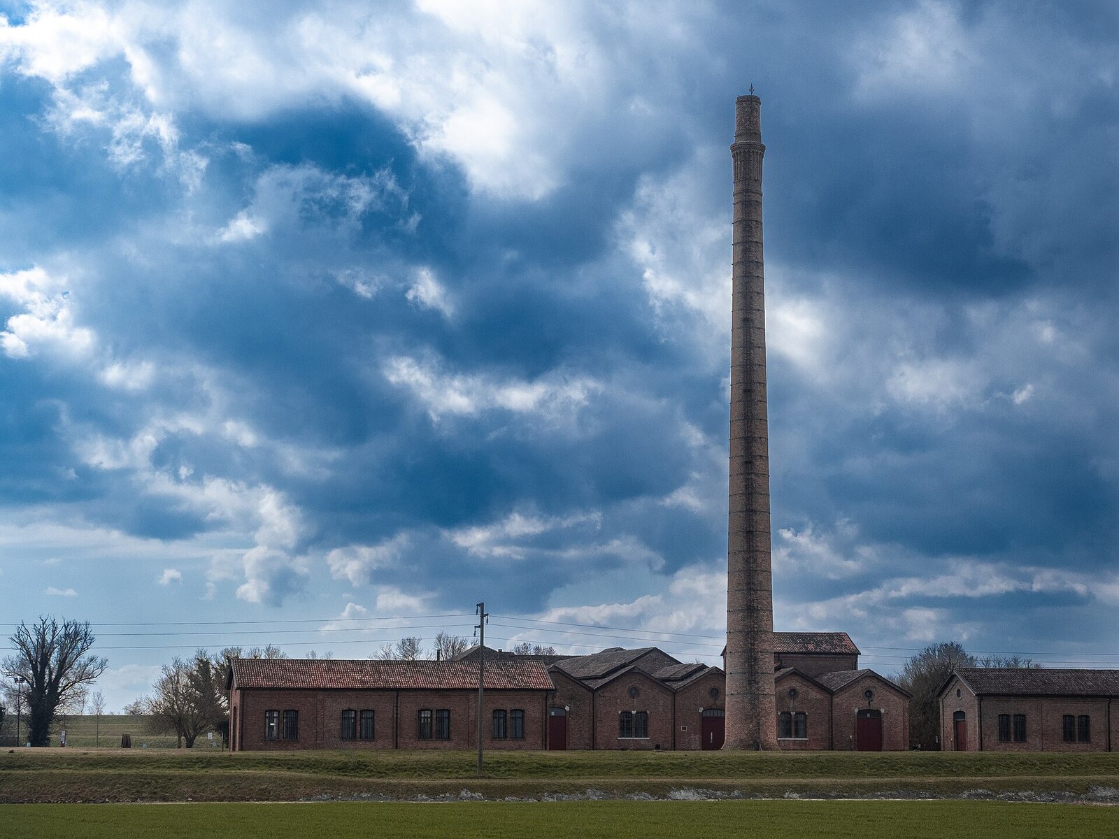 Der Komplex des ehemaligen Schöpfwerks Ca’ Vendramin mit Schornstein in der Landschaft von Taglio di Po